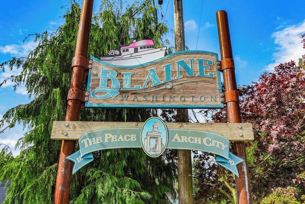 Un panneau en bois portant l’inscription « BLAINE WASHINGTON » et « The Peace Arch City », ainsi qu’une représentation d’un bateau.