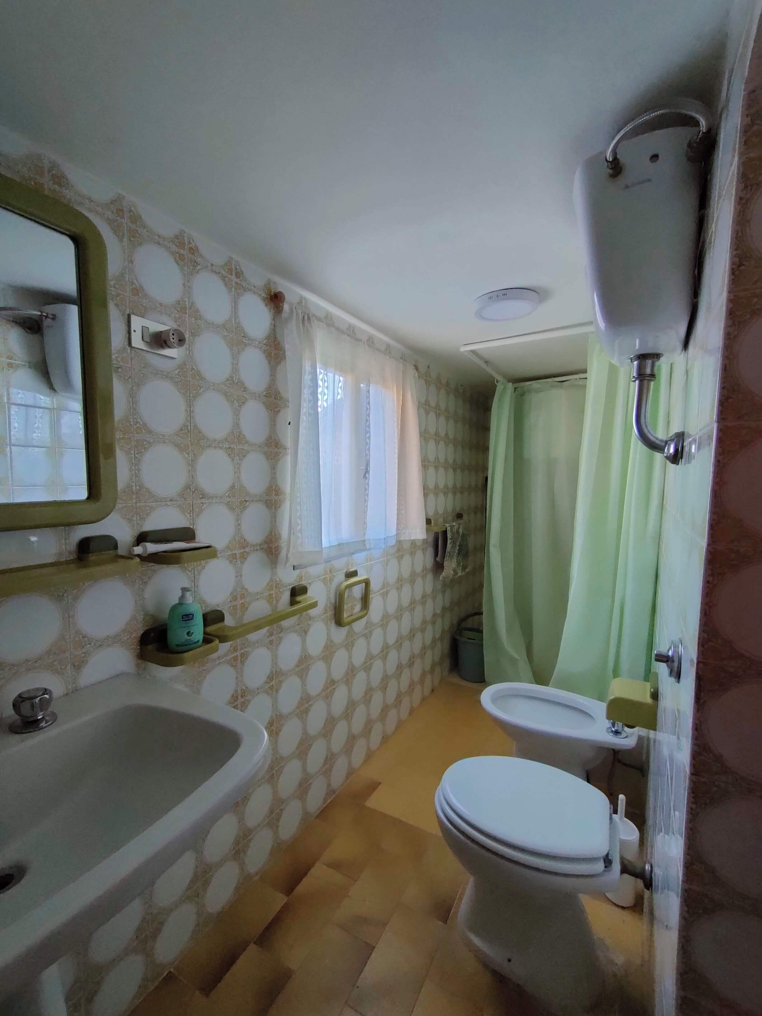 Une petite salle de bain comprenant un lavabo, des toilettes et une douche.