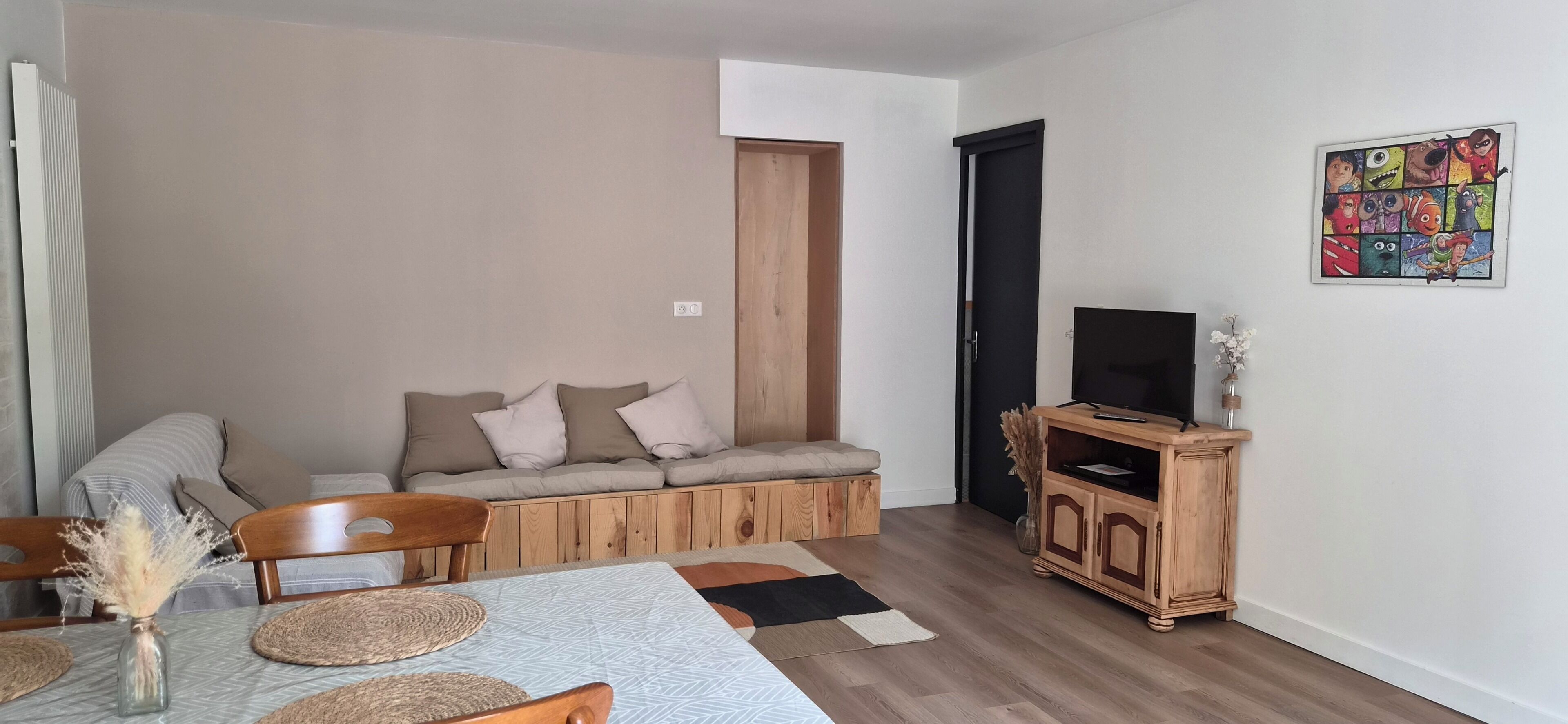 Ein Wohnzimmer mit einer Couch, einem Holzschrank und einem Fernseher.