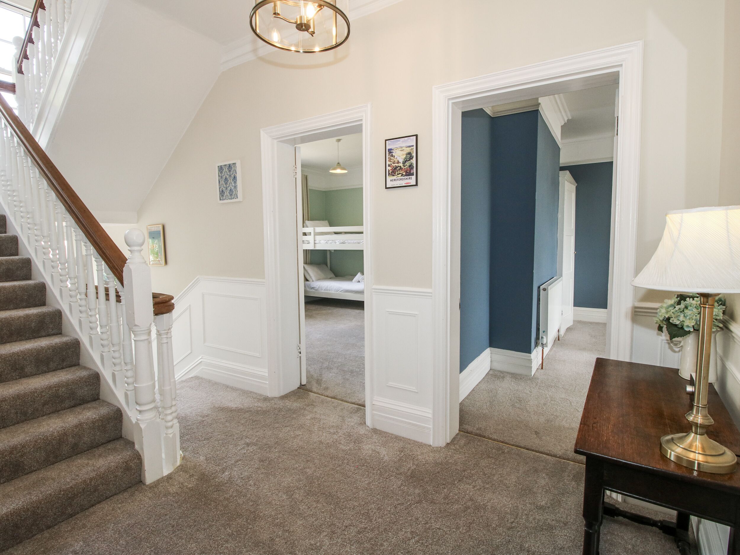 A staircase with white balusters, carpeted steps, and a wooden handrail.
