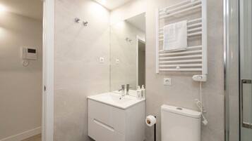 Een douche, handdoeken, zeep, toiletpapier