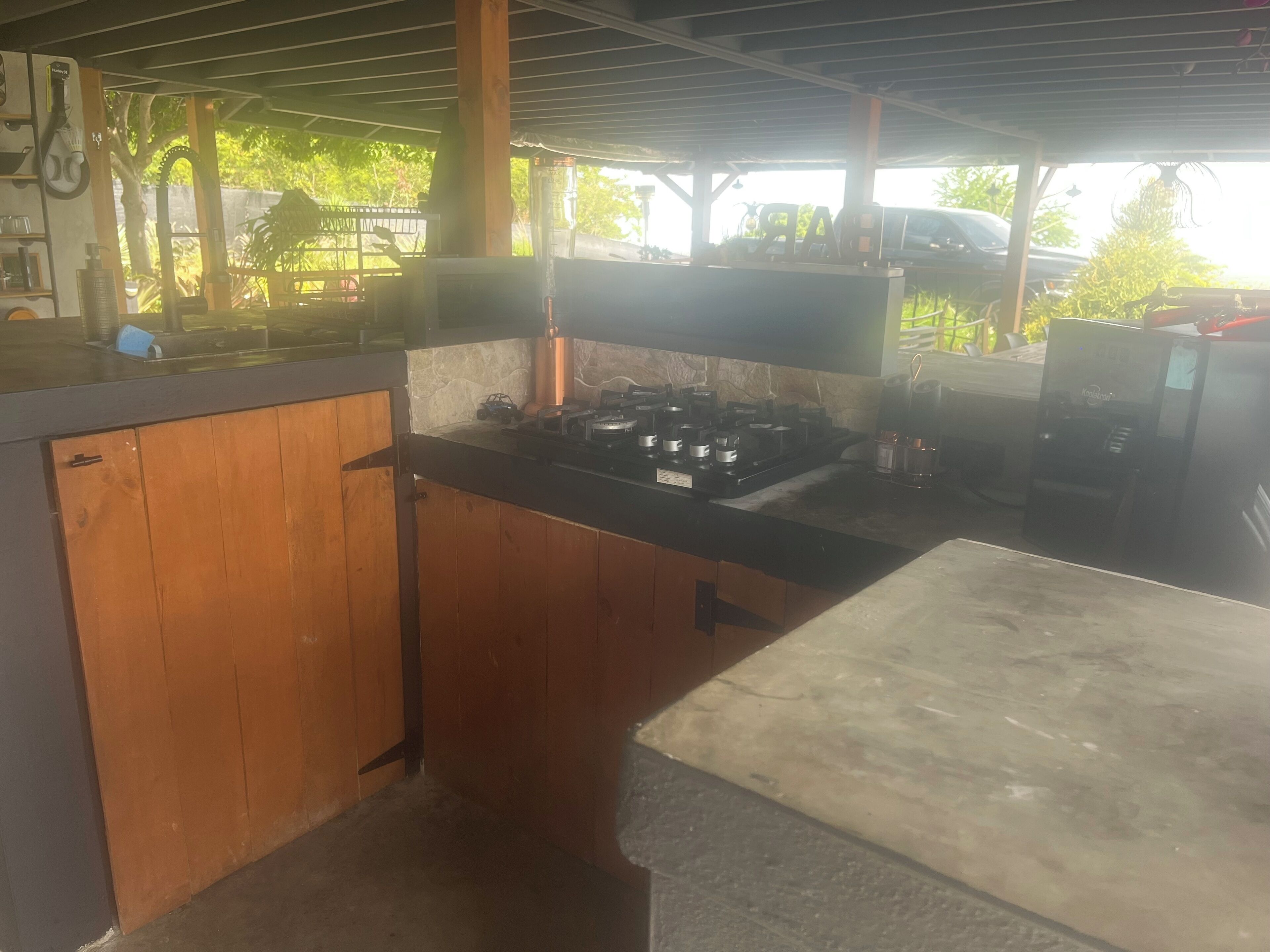 A kitchen with a wooden cabinet, a countertop, and a stove.