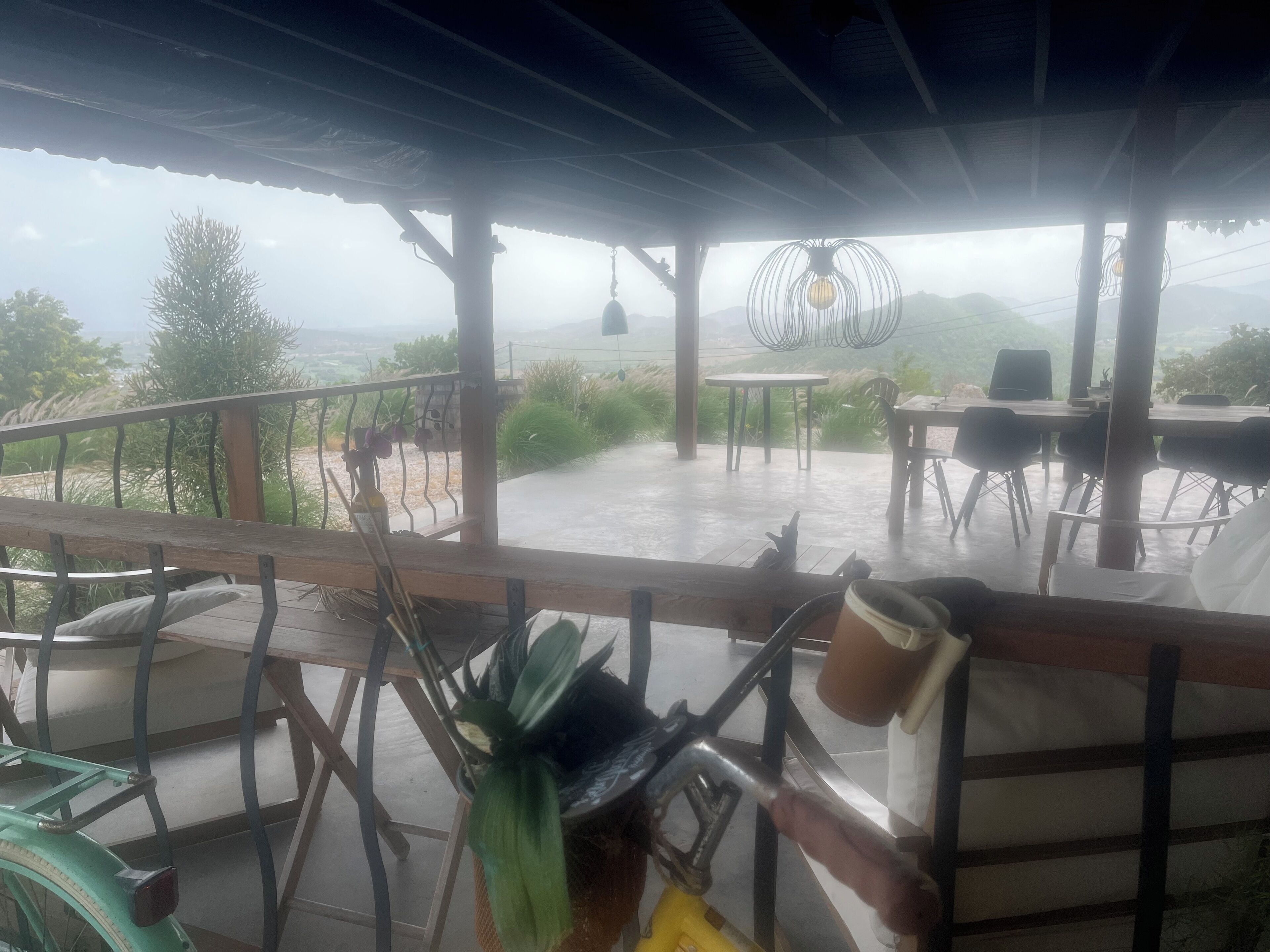 Un espace extérieur abrité, doté de tables et de chaises, offrant une vue sur un paysage pittoresque.