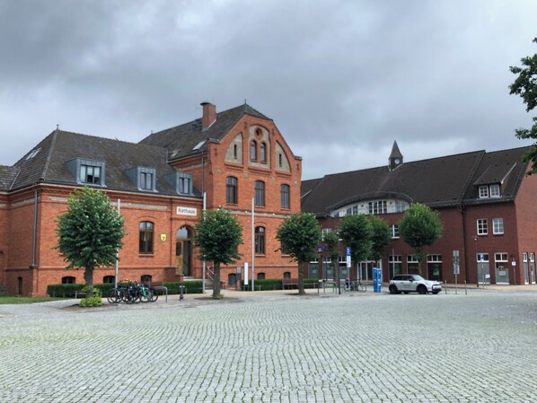 A red brick building with a central arched window and a clock tower.
