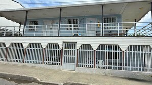 A two-story building with a covered balcony, metal railings, and a gated entrance. - Taybo House By St Hoteles (San Andrés)