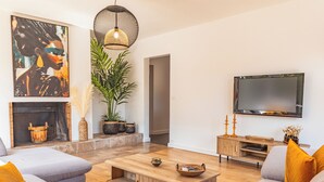 A modern living room with a sofa set, a coffee table, a TV, and a fireplace. - Villa Meia Di Porto-Vecchio (PORTO VECCHIO)