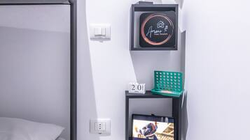 A bunk bed, a wall-mounted TV, a calendar, and a decorative item on a shelf.