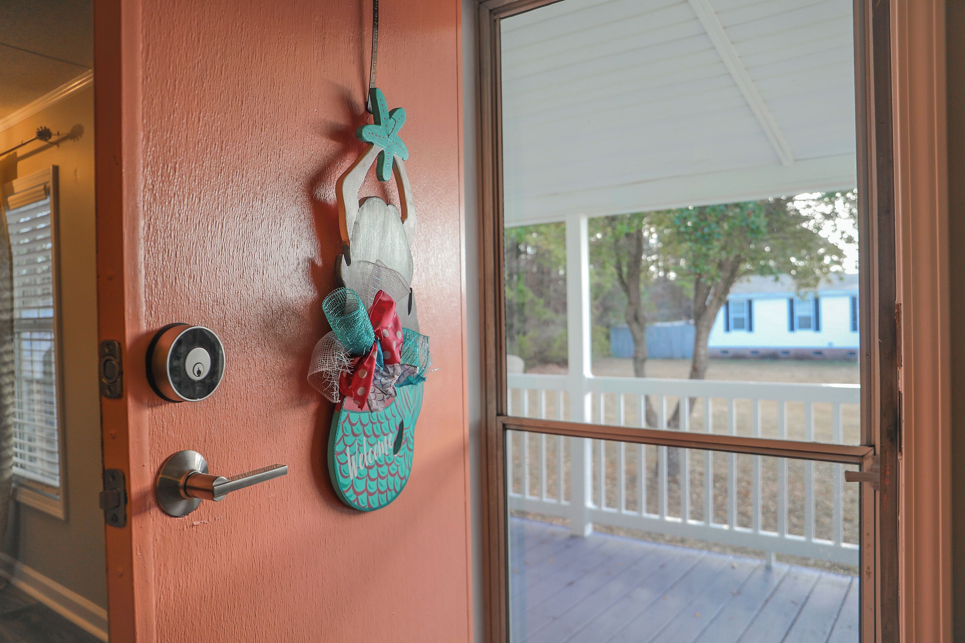 A door with a key lock, a doorbell, and a decorative hanging ornament.
