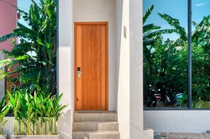 A wooden door with a metal handle, leading to a set of stone steps. - U Villas 2 (Kutuh)