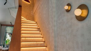 A modern staircase with illuminated steps and wall-mounted lighting fixtures.