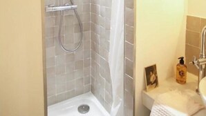 Eine Dusche mit Duschbrause und Wandarmatur.