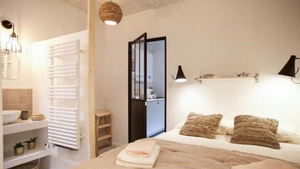 Ein Schlafzimmer mit Bett, Nachttischen, einem Spiegel und einem Kleiderschrank.