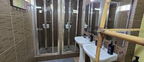 A modern bathroom with a glass-enclosed shower, a white sink, and a mirror.