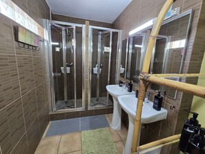 A modern bathroom with a glass-enclosed shower, a white sink, and a mirror. - Dream Lagos B&B (Lagos)