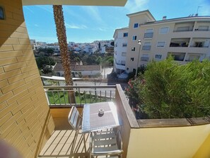 A balcony with a table and chairs, overlooking a residential area with buildings and greenery. - Dream Lagos B&B (Lagos)