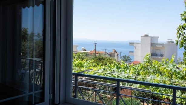 A balcony with a view of the sea and buildings.