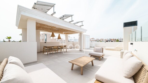 Terraza en la azotea con zona de comedor, asientos y una pérgola.