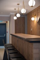 Una cocina moderna con armarios de madera, encimera negra e iluminación colgante.