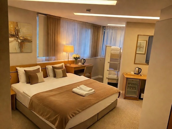 Family Quadruple Room | Minibar, in-room safe, desk, laptop workspace
