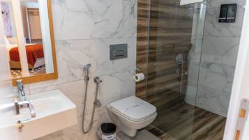 Un baño moderno con lavabo de mármol, inodoro y cabina de ducha de vidrio.