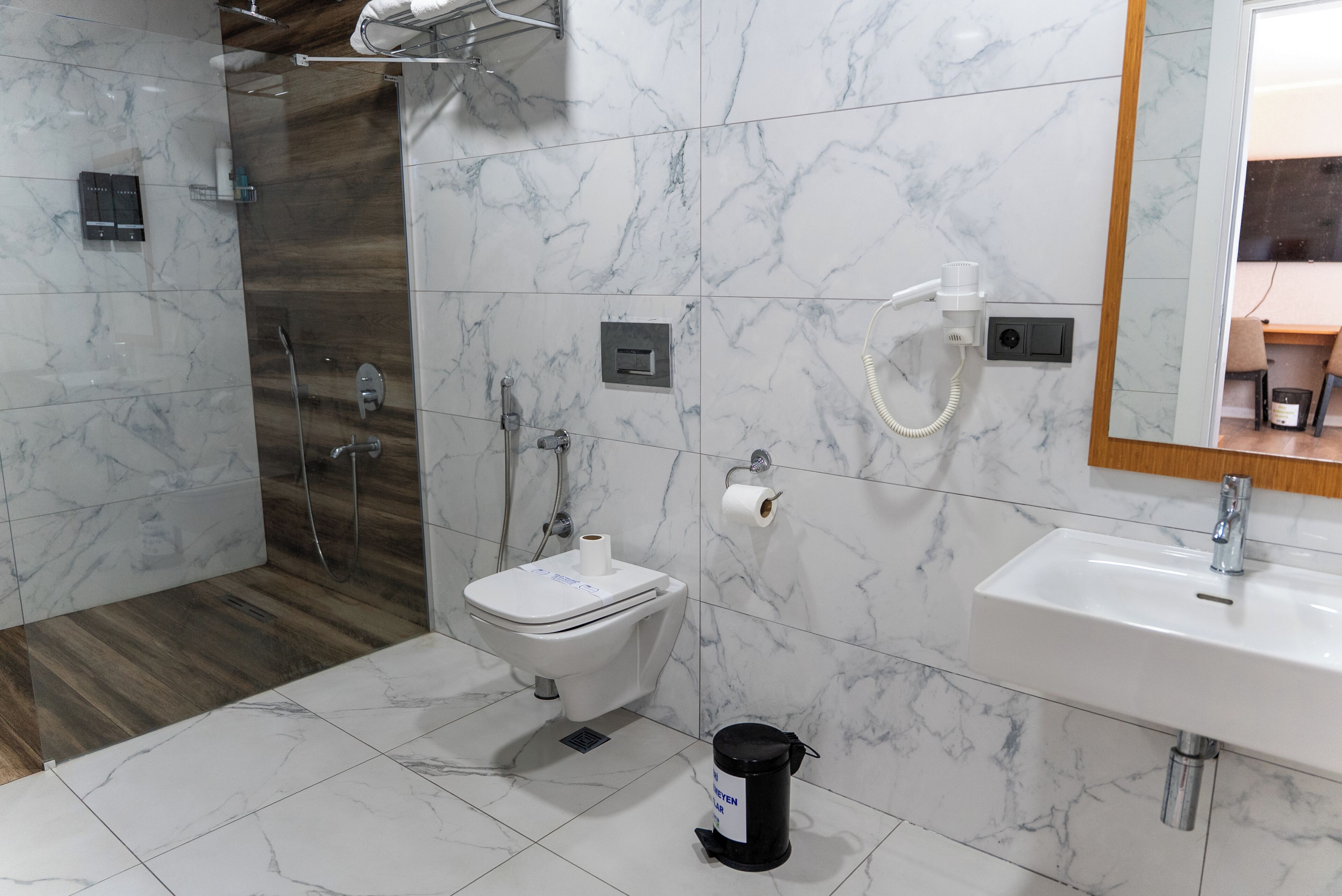 Un baño con inodoro, bidé, ducha y lavamanos.