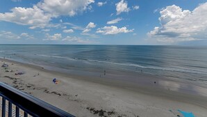 Une plage avec un ciel dégagé et une mer calme.