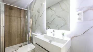 Een douche, handdoeken, zeep, toiletpapier