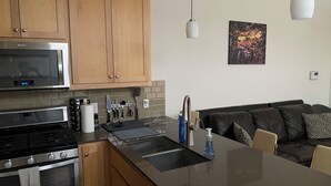 A modern kitchen with wooden cabinets, stainless steel appliances, and a central island.
