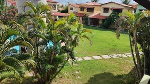 A residential area with houses, a swimming pool, and palm trees.