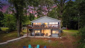 A two-story house with a balcony, outdoor seating area, and a covered patio.