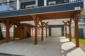A covered parking area with a wooden structure, a garage door, and a house number 1450. - Seaside Escape, Beach Access and Family Paradise! (Myrtle Beach)