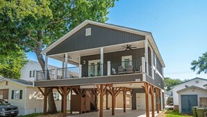 A two-story house with a balcony and a covered porch.