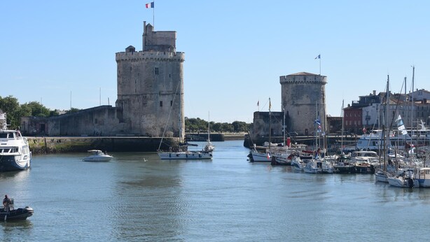 A historic tower and a marina with boats. - Appartement Proche Plage (La Rochelle)