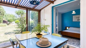 A room with a bed, a table with a hat, and a potted plant.