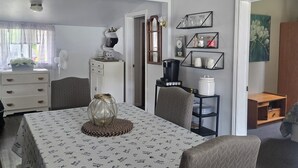 A dining area with a table set for two, a ceiling fan, and a view of the adjacent living room. - Charming 3-bedroom cottage in serene Trent Hills with WiFi (Trent Hills)