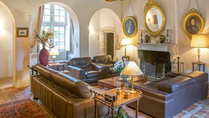 A traditional living room with leather sofas, a fireplace, and ornate mirrors. - Gorgeous home in Guérigny (Guérigny)