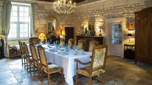 A dining room with a stone wall, a chandelier, and a table set for six. - Gorgeous home in Guérigny (Guérigny)