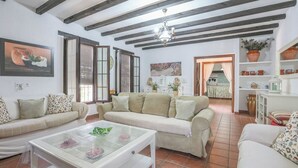 Ein Wohnzimmer mit einer Couch, einem Couchtisch und einer Küche im Hintergrund.