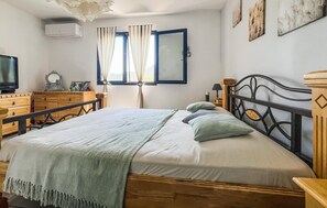 A bedroom with a wooden bed, a television, a dresser, and a window with curtains. - Stunning home in St-Florent-sur-Auzonne (St-Florent-sur-Auzonne)
