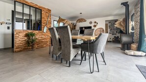 A modern dining area with a wooden table and grey upholstered chairs. - Lovely home in Saint-Césaire-de-Gauzi with WiFi (Saint-Césaire-de-Gauzi)