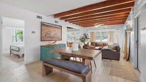 Amplia sala de estar con un banco de madera, una mesa de comedor y un sofá.