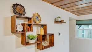 A wall-mounted wooden shelf unit with decorative items and a mirror. - 3BR w/ shared Hot Tub & Backyard Oasis (Reno)