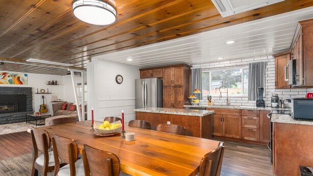 A spacious kitchen with wooden cabinets, a granite countertop, and a built-in island. - 3BR w/ shared Hot Tub & Backyard Oasis (Reno)