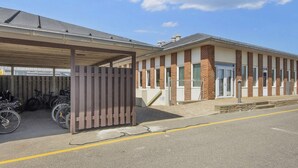 Een gebouw met een overdekte parkeerplaats en een gevel van baksteen.
