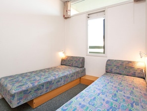 A small room with two single beds, a window, and a wall-mounted lamp. - 4 Person Holiday Home on a Holiday Park in Fano (Fano)