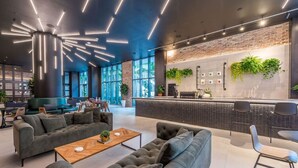 A modern lobby with sofas, a coffee table, and a reception desk with plants. - New Penthouse Downtown Heated pool & jacuzzi (Miami)