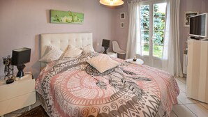 A bedroom with a large bed, a bedside table with a lamp, a small table with a candle, and a window with curtains. - Beautiful home in Morières-lès-Avignon (Morières-lès-Avignon)