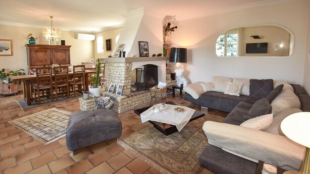 A spacious living room with a fireplace, a dining area with wooden furniture, and a cozy seating arrangement. - Beautiful home in Morières-lès-Avignon (Morières-lès-Avignon)