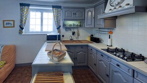 A compact kitchen with a central island, a gas stove, and a microwave. - 1 bedroom gorgeous home in La Tranche-sur-Mer (La Tranche-sur-Mer)