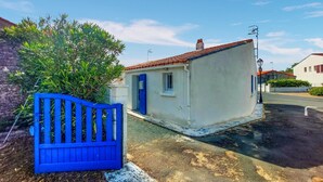 A small, single-story building with a red-tiled roof, a blue door, and a white exterior. - 1 bedroom gorgeous home in La Tranche-sur-Mer (La Tranche-sur-Mer)